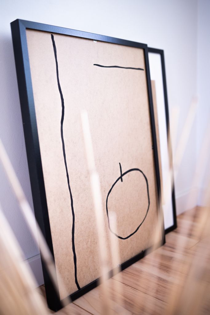 Minimalist abstract art frame with black lines on a brown background, perfect for modern decor.